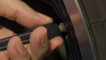 Inflating tire. man hand open valve cap and inflate car tyre before driving. video