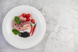 Pork white plate with pepper seeds and tomatoes. photo