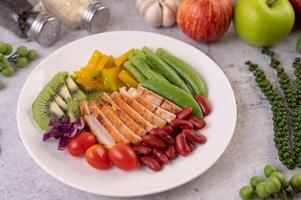 Chicken steak with peas, tomatoes, kiwi and pumpkin. photo