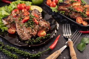 Pork steak topped with white sesame and fresh pepper seeds along. photo