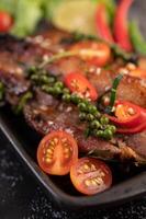 Pork steak topped with white sesame and fresh pepper seeds along. photo