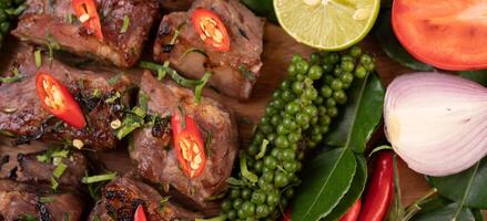 Pork steak topped with white sesame and fresh pepper seeds along. photo