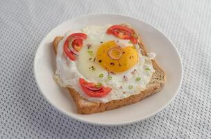 pan colocado con un huevo frito con tomates, harina de tapioca. foto