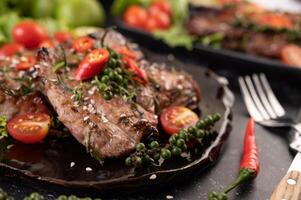 Pork steak topped with white sesame and fresh pepper seeds along. photo