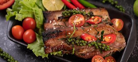 Pork steak topped with white sesame and fresh pepper seeds along. photo