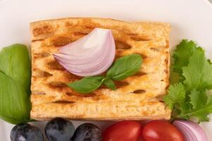Breakfast consisting of black grape bread, tomatoes. photo