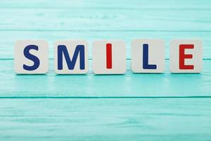 Word smile on blue wooden background. Selective focus. Copy space. Motivation concept