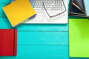 Workplace with copy space and colorful accessories on blue wooden table. Top view photo