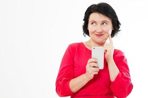 Attractive middle-aged woman relaxing reading her text messages on her mobile phone with a quiet smile copy space photo