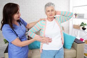 Close-up of elder woman training with physiotherapist, elderly woman with nurse at home photo