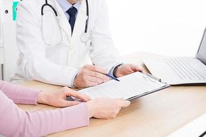 Doctor and patient are discussing something, just hands at the table, medical insurance. photo