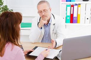 male doctor discusses contract with his patient in medical office