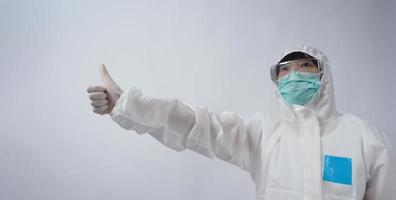 Doctor in PPE suit gesture make hand sign. Represent victory win over virus. photo