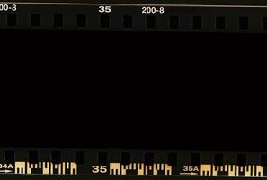 Tira de fotogramas de película de 35 mm escaneada con signos de uso en el bisel. foto