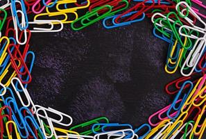 Colored paper clips isolated on dark background
