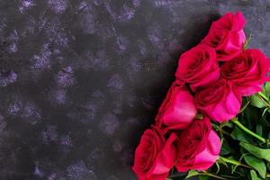 Bouquet of pink roses on dark background. Top view photo