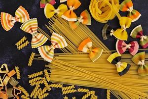 Dry pasta background. Different pasta on dark background. Flat lay. Top view. photo