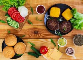 Ingredients for burger on wooden background. Top view photo