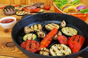 Grilled vegetables and handmade burger. Zucchini, eggplant, mushrooms, pepper on the grill. Top view photo