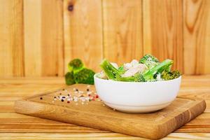 Chicken with broccoli on a wooden background photo