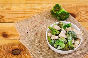 Chicken with broccoli on a wooden background photo