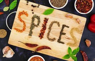 Different spices on dark background. Top view photo