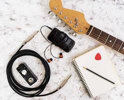 Music stuff. Guitar, guitar pedal, headphone, mobile phone on white background. Top view. Flat lay photo