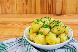 Young potatoes on wooden background photo
