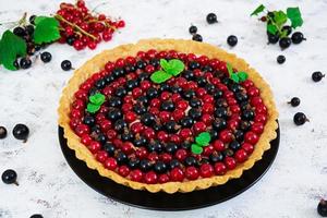 Delicious tart with custard and currant on white background photo