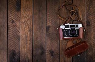 Vintage old camera on rustic wooden background. Top view