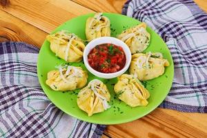 Delicious manti dumplings on wooden background photo