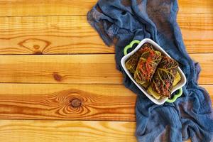 Cabbage rolls with savoy leaves on wooden background. Top view photo