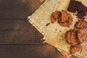 Cookies with chocolate on dark wooden background