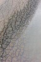 asfalto agrietado de fondo con agua. foto