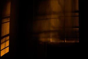 Window blinds blur in dark room with light.