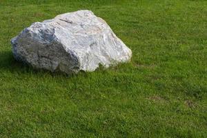 Large gray rocks on green grass. photo
