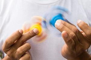 Blue and yellow spinners both in hands. photo