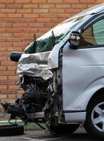 Van collapsed near a brick wall. photo