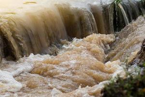 The turbid water flows like a waterfall. photo