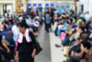 Blurring of crowd sitting in waiting station. photo