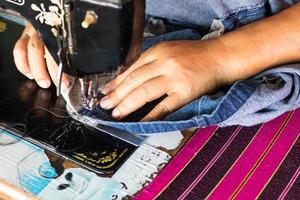 reparar jeans con una vieja máquina de coser. foto