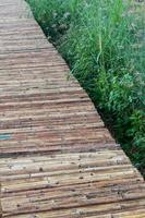 Close up of bamboo bridge with weed grass. photo