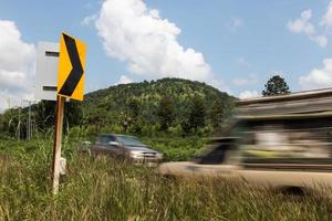 Cars passing signpost bends. photo