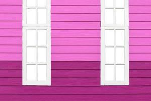 Paneles de madera falsa púrpura con ventanas de madera blanca. foto