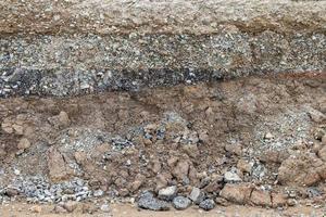 Rocky soil background under paved road. photo