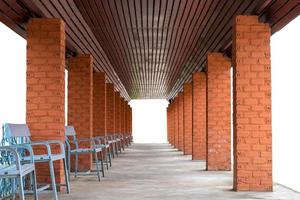 Square poles, brick walls and many benches. photo