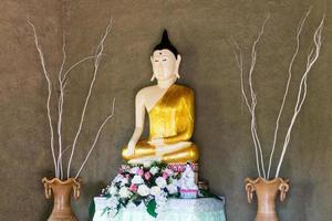 Statue of Buddha with rough cement wall. photo