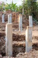 Many concrete poles in the excavated soil.
