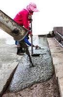 los trabajadores vierten cemento para igualar. foto