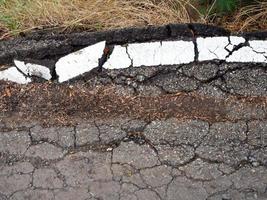 Cracked asphalt with white lines photo